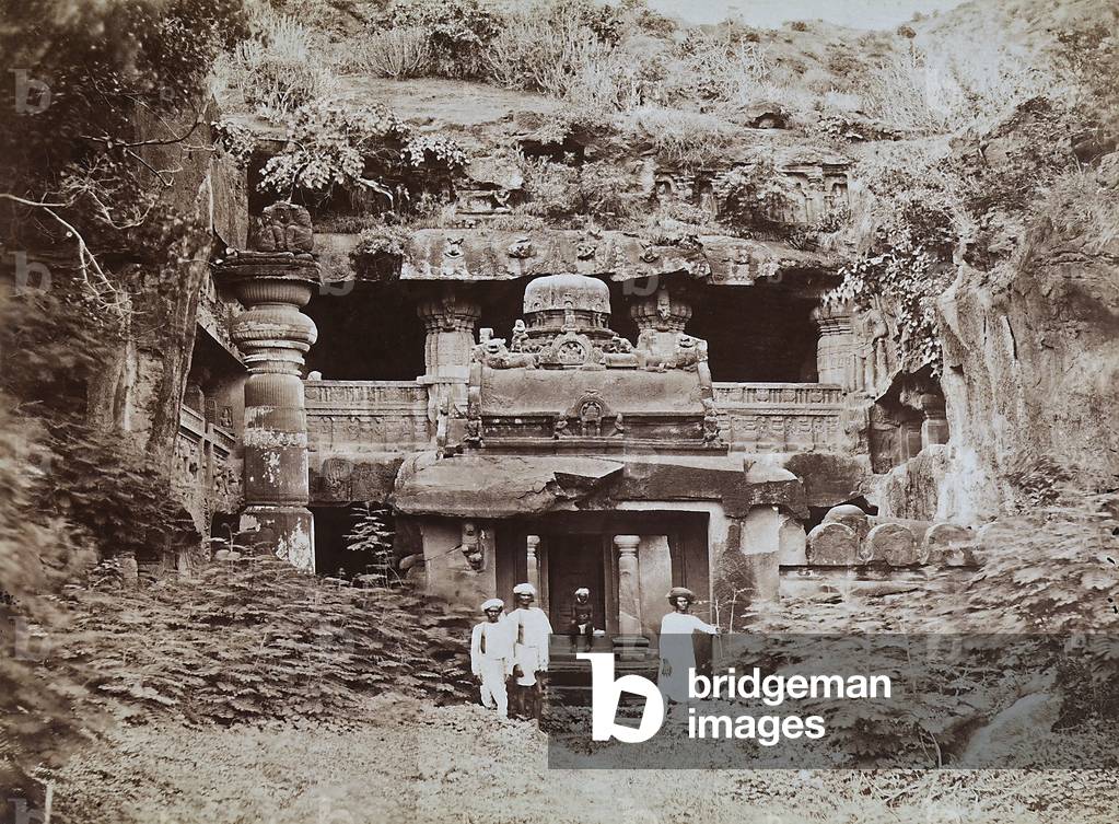 Entrance to the temple of Felsen in the Isle of Elephanta, placed in the waters of Bombay harbour. In front of the temple some Indians can be seen, 1930-1960 (print on double-weight paper)