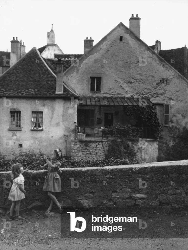 Two little girls playing outdoors in Semur, Burgundy (b/w photo)