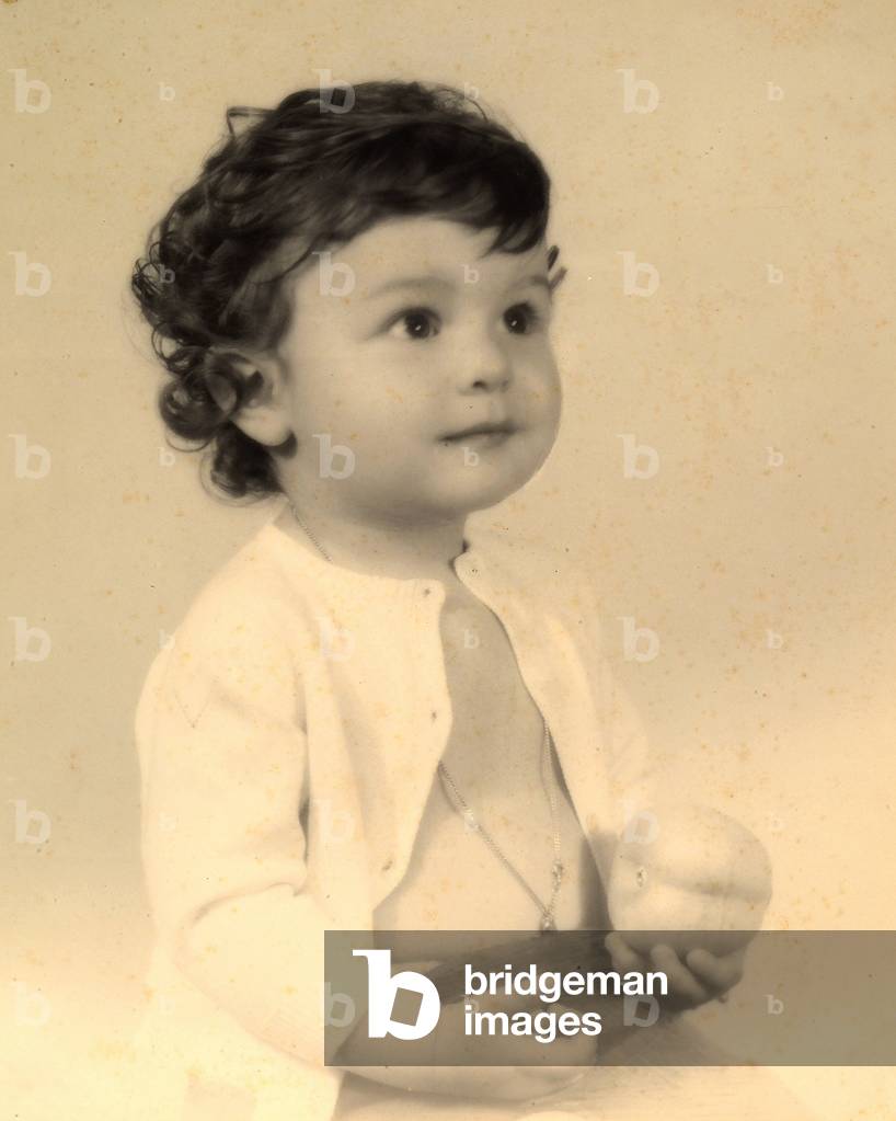 Portrait of a little boy with some fruit in his hand