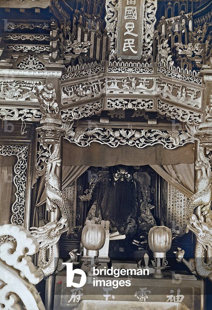 An altar with a statue and other sacred items inside a Chinese temple