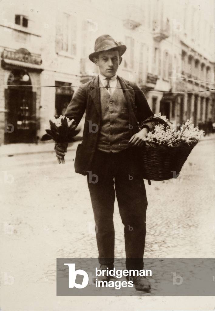 Full-figure portrait of a flower vendor.