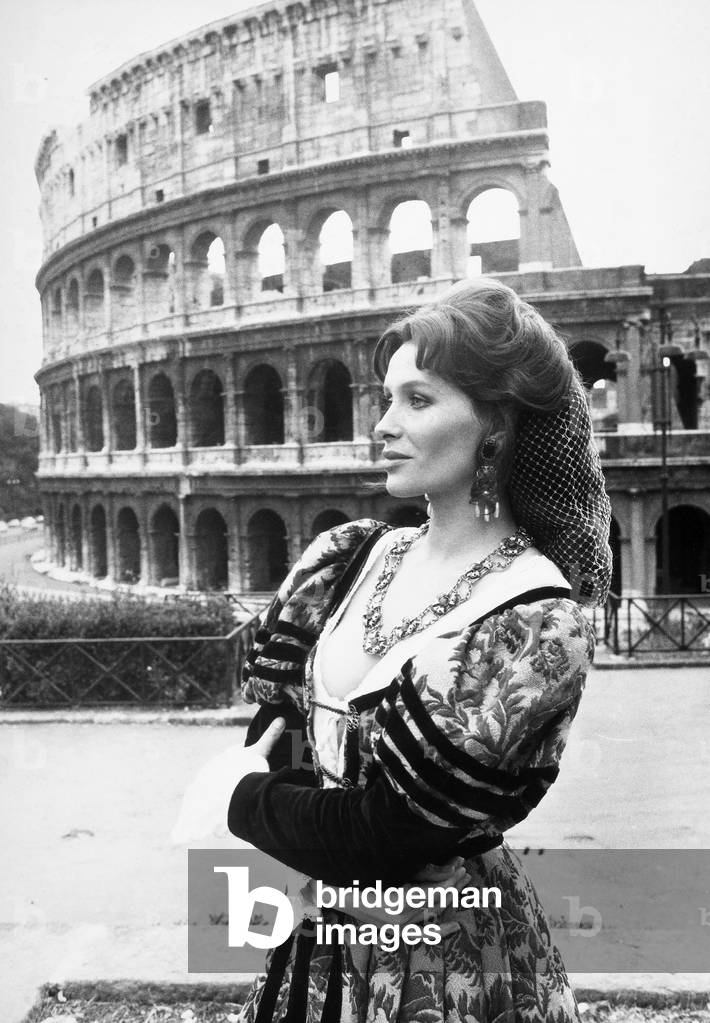 Portrait of the actress Erika Blanc wearing Renaissance period clothing in front of the Colosseum.