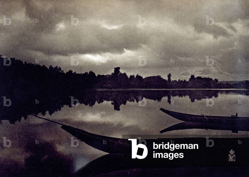 Enchanting view of the Tanaro river near Pollenzo (Italy). In the foreground, partially visible, two small moored boats