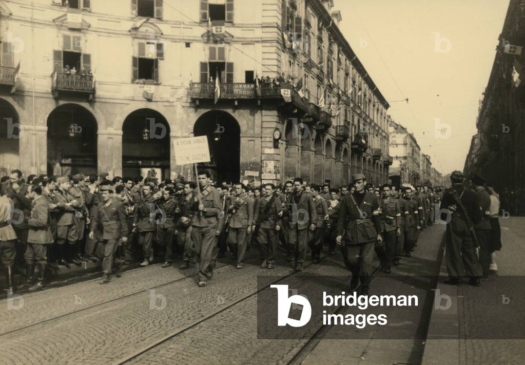 Partisan troops of the Resistance march along a street in Turin during the celebrations for the liberation of the city, 06/05/1945 (b/w photo)