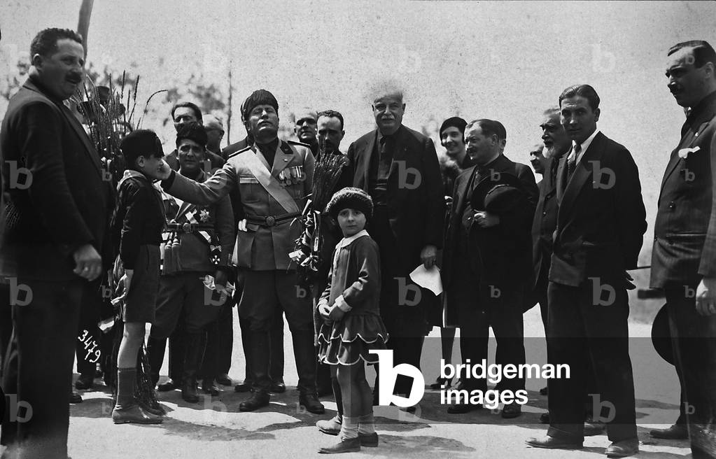 Album showing the visit made by S.E. Benito Mussolini to the Padule farm in Bagno a Ripoli, property of Prince Senator Piero Ginori Conti: Il Duce and Count Ginori shown with a group of people during the visit to his property; two children paying homage to Il Duce, 17/06/1930 (b/w photo)