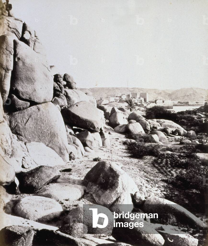 Panorama of an archaeological site in upper Egypt. In the foreground, stone masses