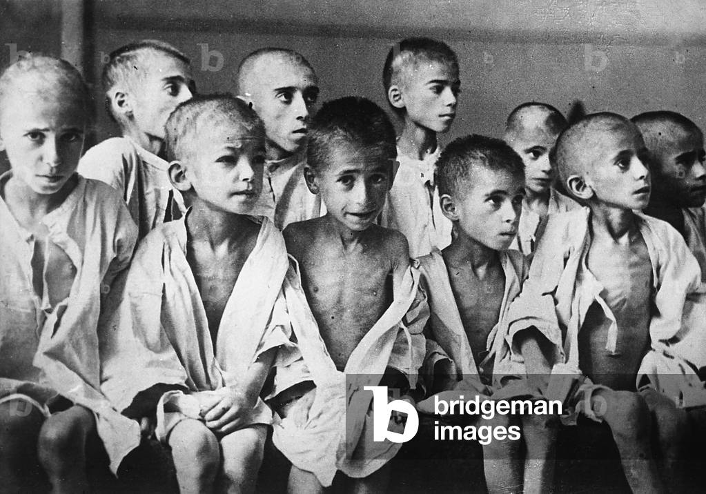 A group of children demonstrating the hardship suffered from imprisonment in the concentration camps (b/w photo)