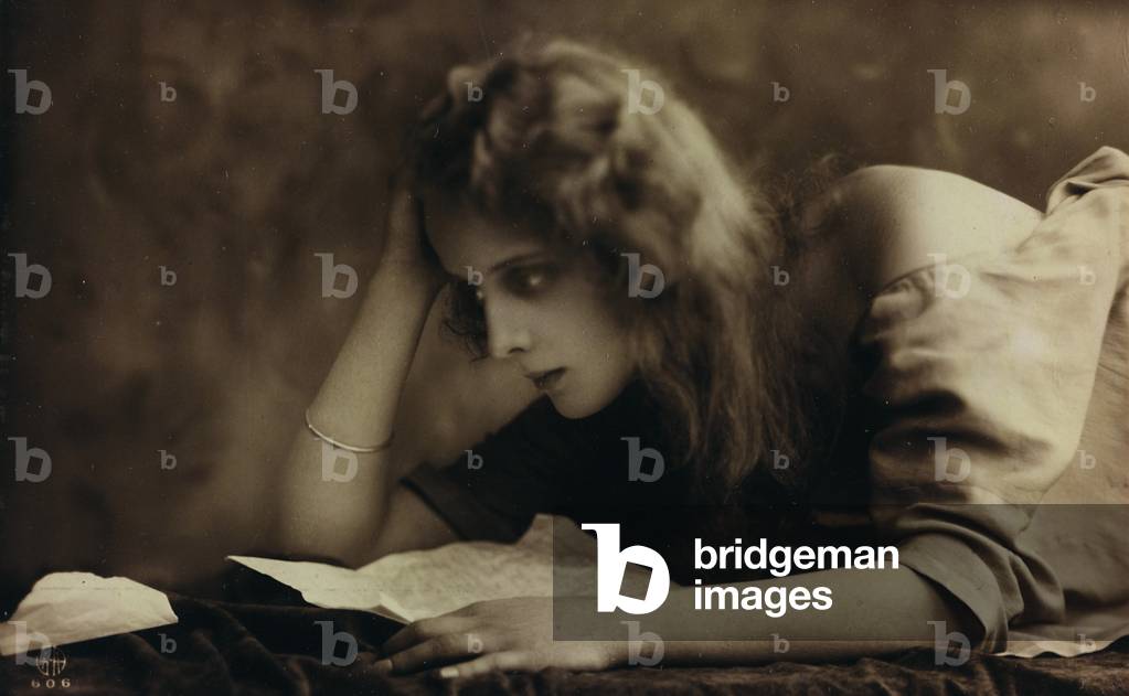 Portrait of a young woman reading a letter, postcard