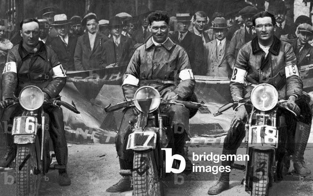 French motorcyclists pose at the end of a race: Garrot (1st place), Quenette (2nd place), and Gillot (3rd place).