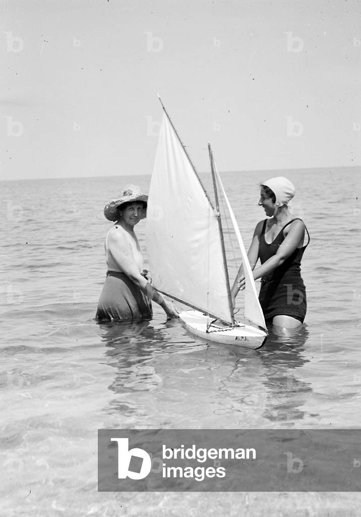 Two swimmers with a model of a boat