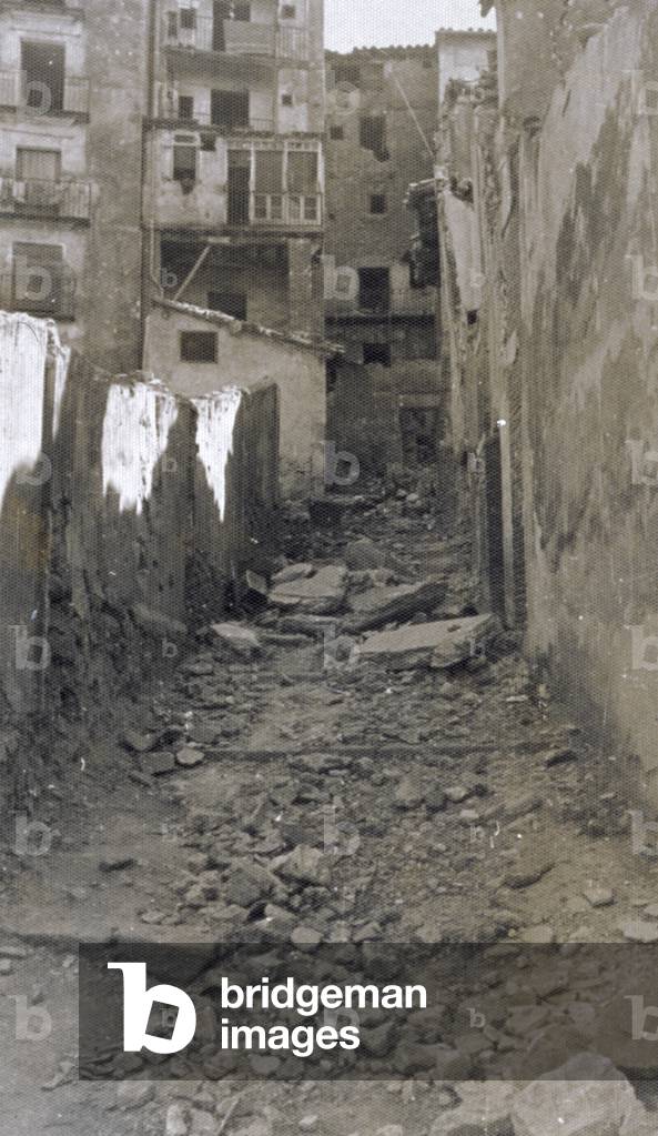 A small street in Teruel, where the effects of the bombings of the Spanish civil war are visible. The street is covered with rubble and the buildings are seriously damaged (b/w photo)