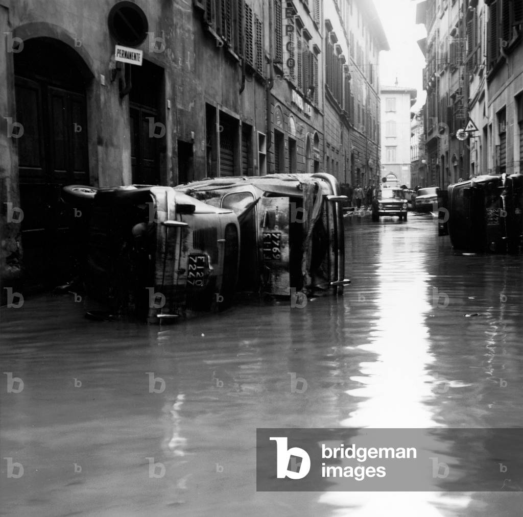 Capsized cars in Via Faenza, after the flood of Florence, 4th November 1966 (b/w photo)