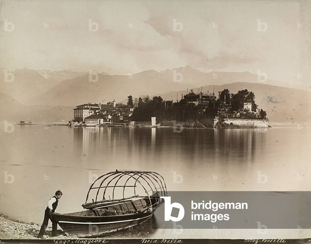 Typical boat with circular framework moored on the shore; in the background l'Isola Bella on Lake Maggiore