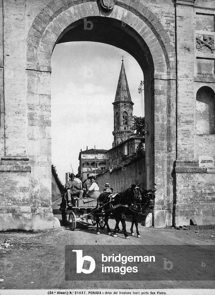 The arch of Porta San Pietro in Perugia. A cart pulled by horses is in the foreground.