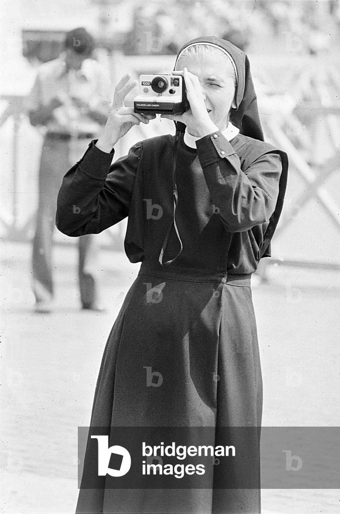 A nun takes a photograph in St. Peter's Square