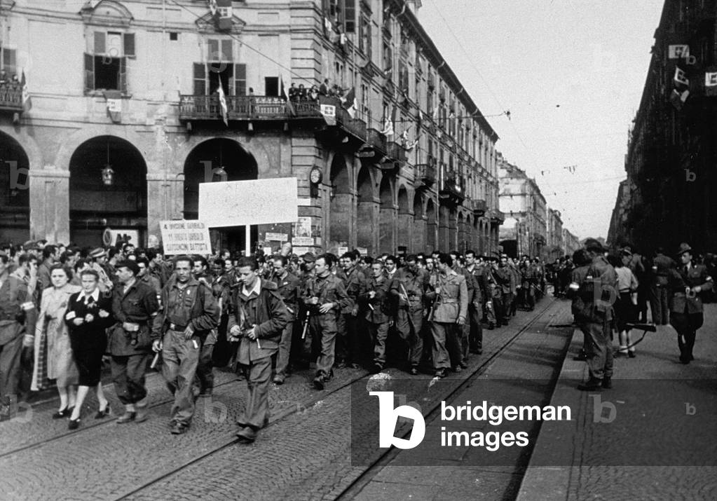 Partisan troops of the Resistance marching along a street in Turin celebrating the liberation of the city, 06/05/1945 (b/w photo)