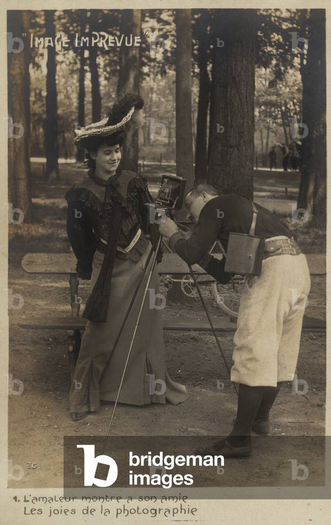 A photographer teaches a young woman how to work the mecchanism of her camera