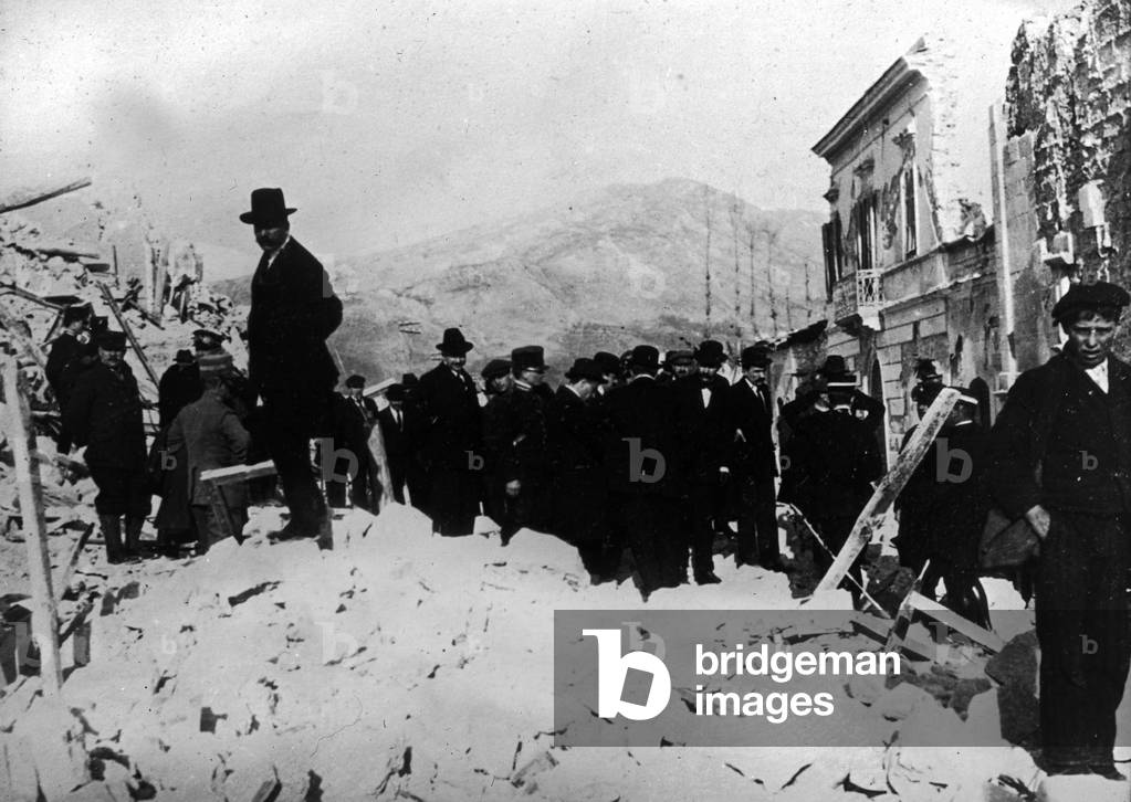 Earthquake of 13 January 1915: group of men in the ruins of Avezzano, Italy (b/w photo)