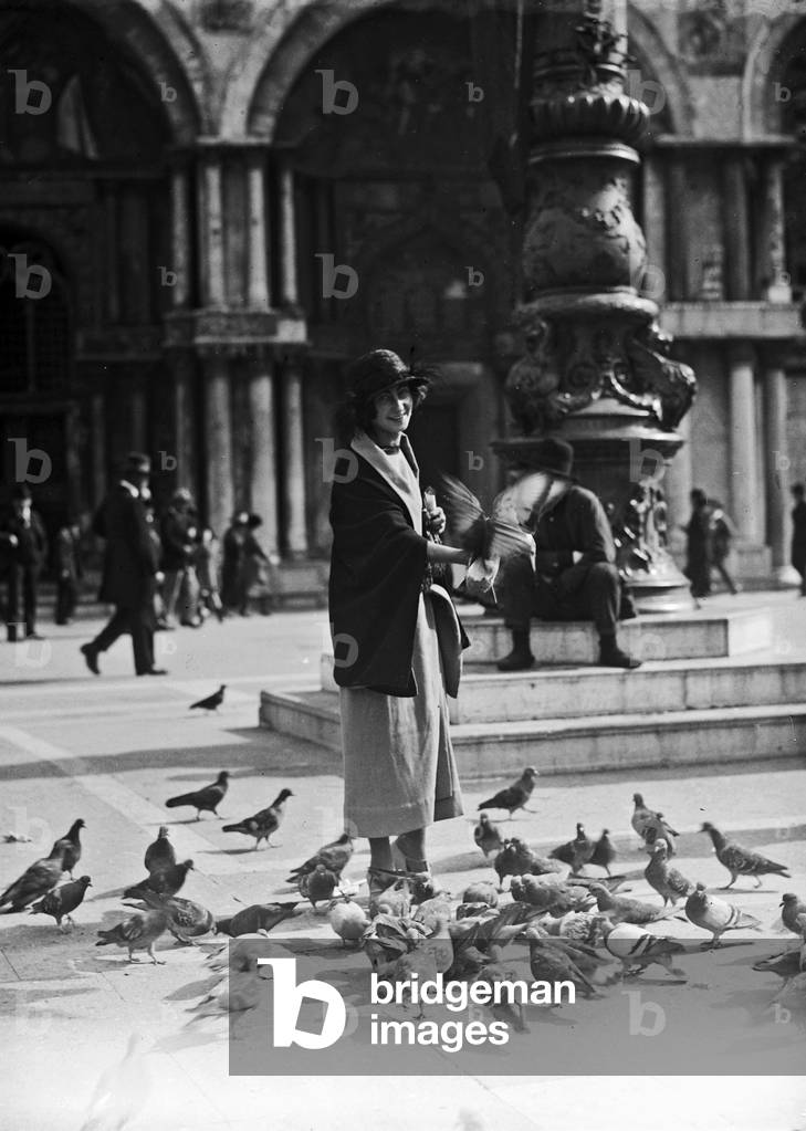 Girl surrounded by pigeons in Piazza San Marco in Venice