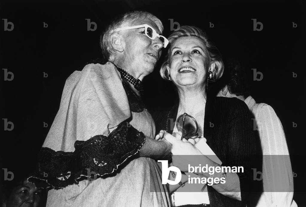 Giulietta Masina and Lina Wertmüller smiling and holding hands.