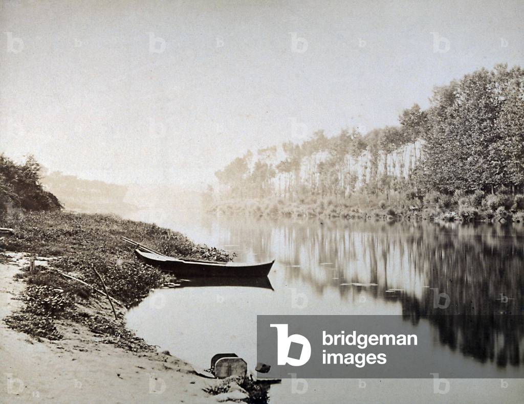 River landscape. In the foreground a boat on the shore