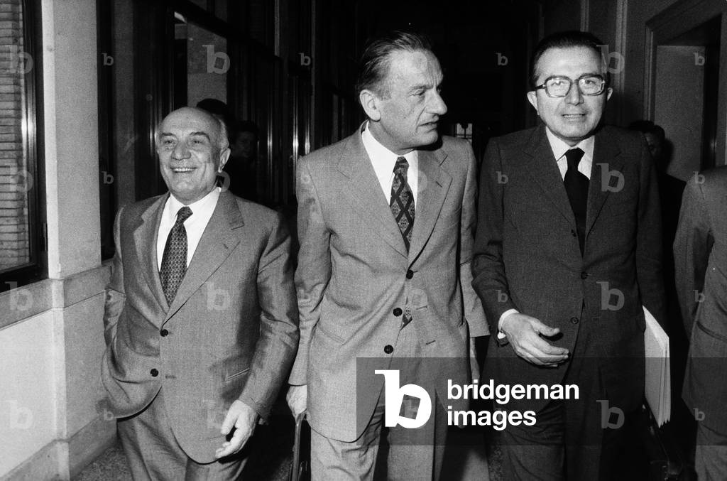 Fanfani, Zaccagnini and Andreotti talking while walking along a corridor.