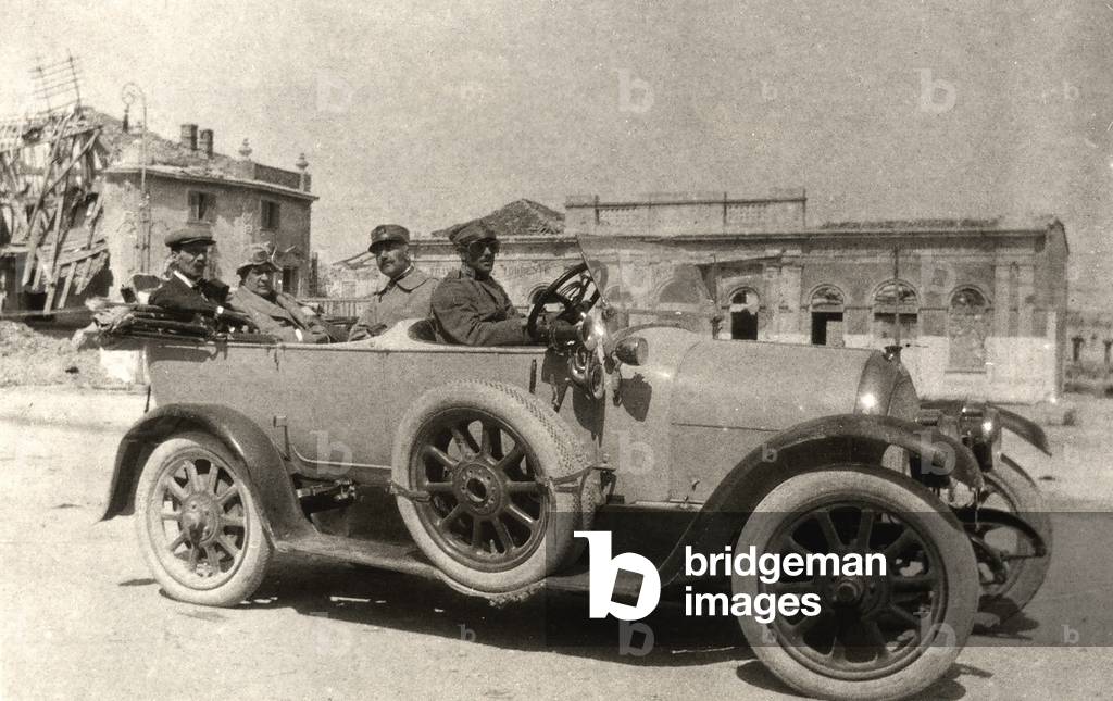 Ugo Ojetti, Tito Ricordi and Marco Praga, aboard an automobile, drive down a street of Grado. The photo was taken in 1916 during WWI.