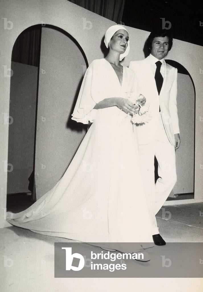 Fashion show at the Piper nightclub: a man and woman are wearing wedding clothes designed by Sarli.
