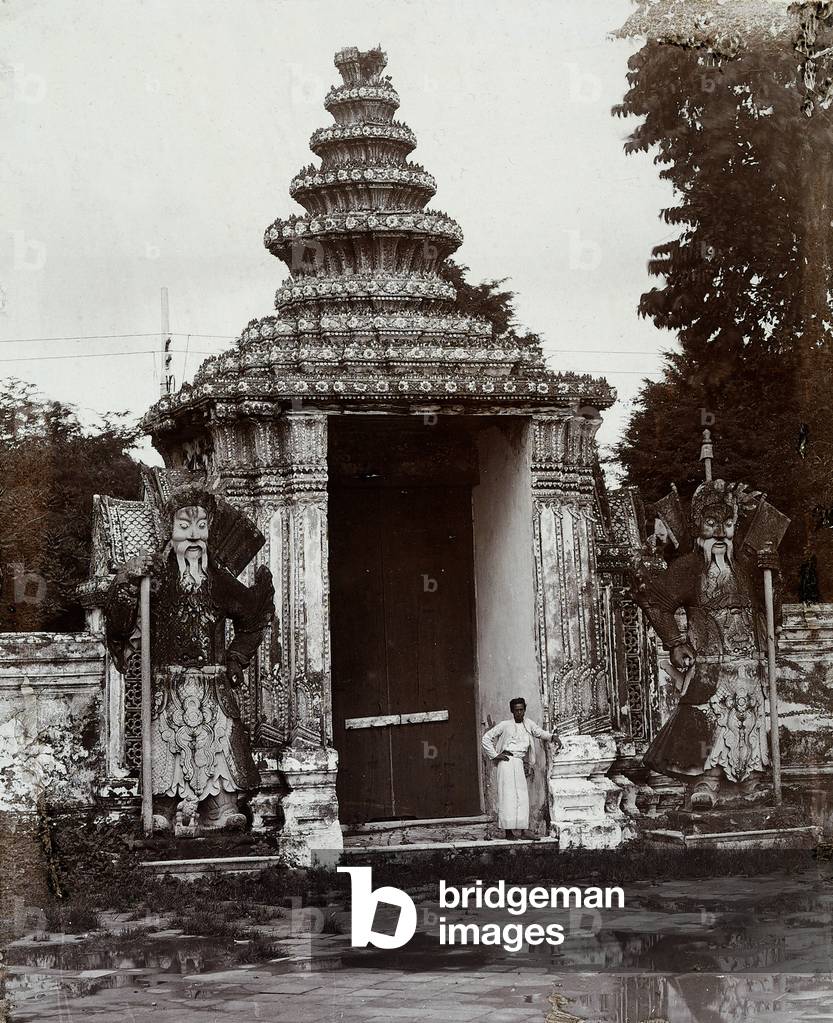 A man photographed in front of the entrance to a thai temple, 1900 (print on double-weight paper)