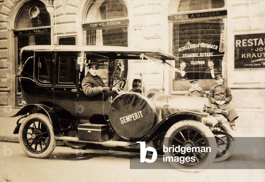Portrait of a driver aboard his automobile, stopped in front of a restaurant.