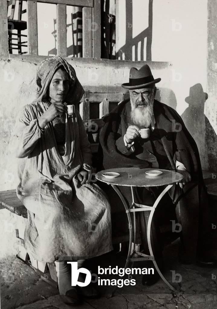 The writer Tristan Bernard, photographed seated at a cafe in the company of a native, during a voyage in Northern Africa,  1937 (print on double-weight paper)