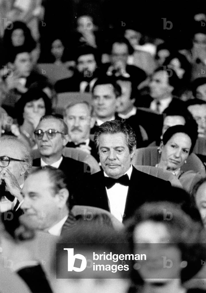 Part of the Orchestra in a theater. In the foreground The actor Marcello Mastroianni, on the left partial view of Federico Fellini