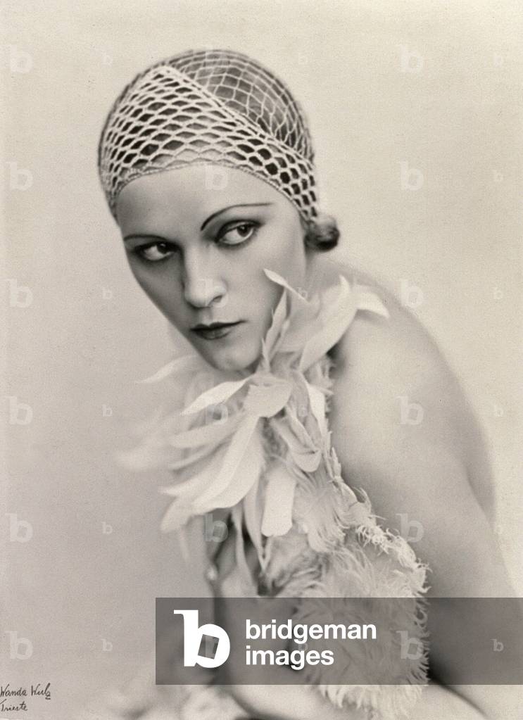 Portrait of a woman wearing a fishnet hat and a feather boa