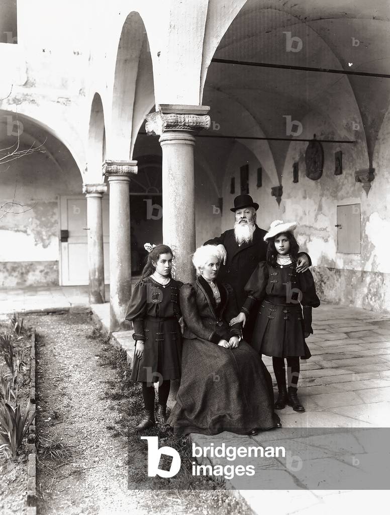 Two little girls and an elderly couple, photographed in a cloister