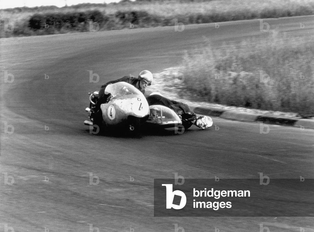 Two motorcyclists in a race, on a two seater motorcycle