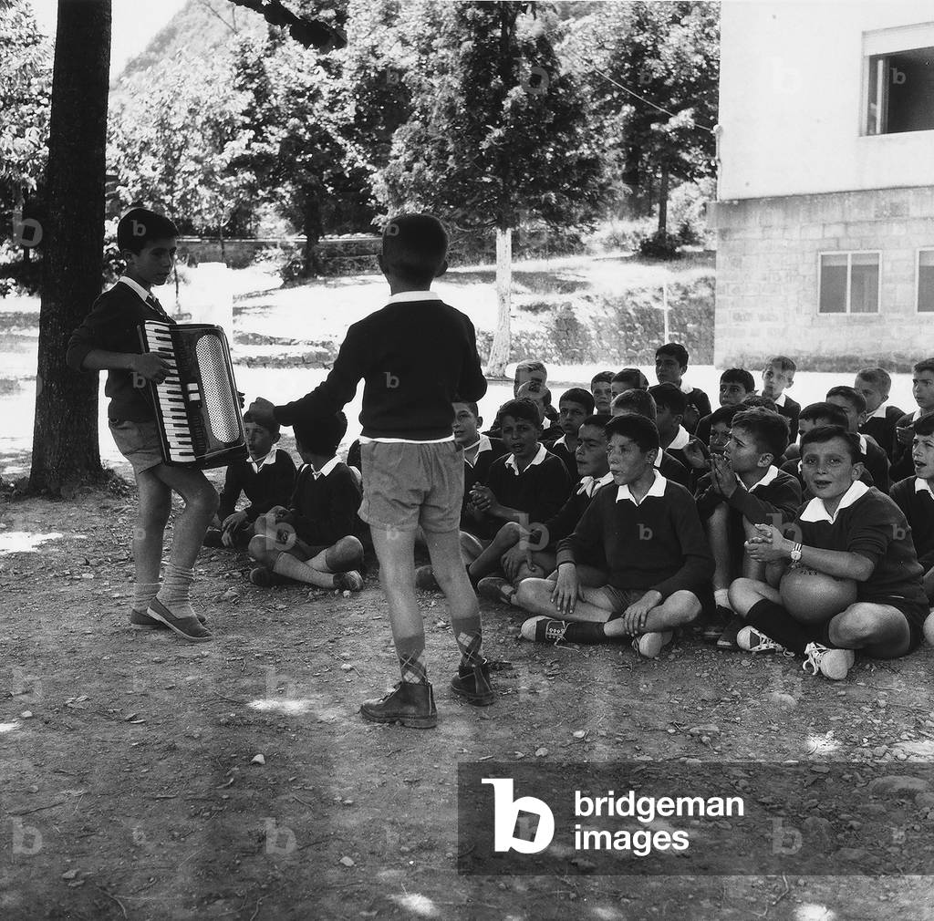 A boy's class at a secondary school singing during a break.