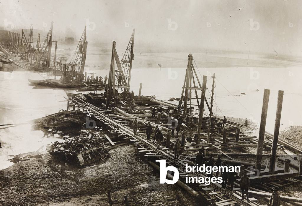 Series of pile drivers during the construction of a wooden bridge for a temporary detour over the Piave of the Treviso, Italy-Motta di Livenza, Treviso, Italy railway line, work done by the Cleto e Mauro Fratelli Toschi construction firm of Bologna, 15/02/1919 (b/w photo)