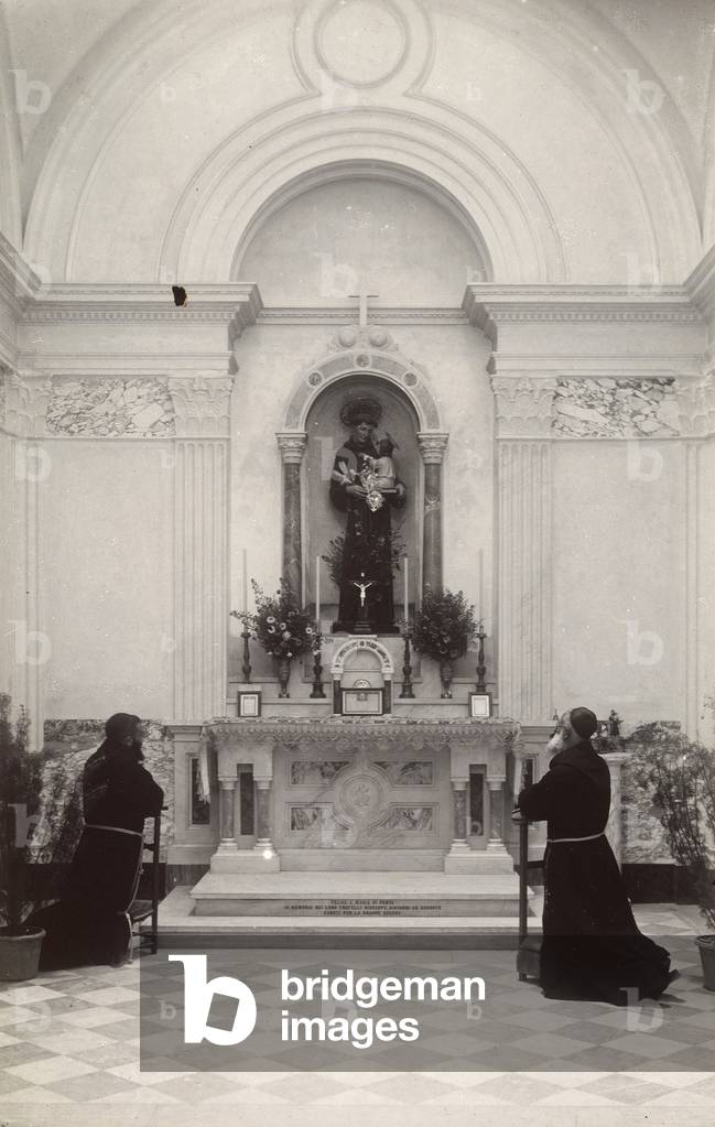 Monks kneeling before an altar with a statue of St. Anthony