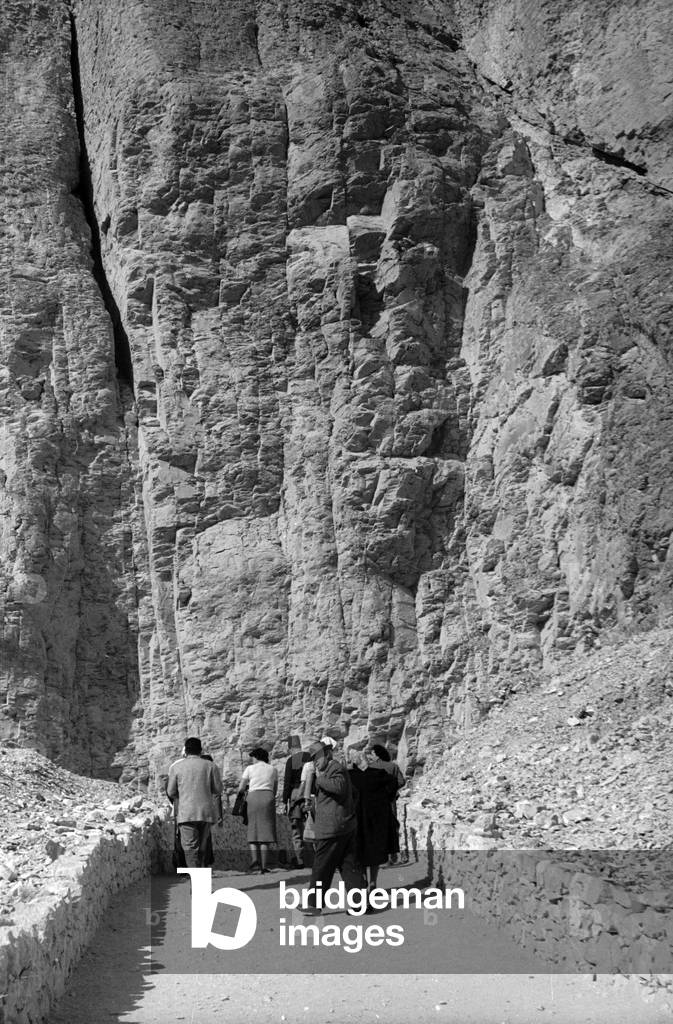Tourists stroll between cliffs, Thebes (ancient Luxor)