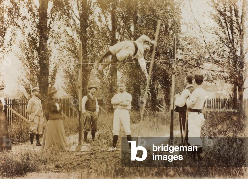 Portrait of a man who trains in the pole vaulting in front of some spectators
