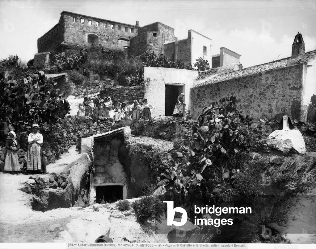 View with people of the Castle and Grottos, considered ancient Roman tombs, both located on the Island of San'Antioco.