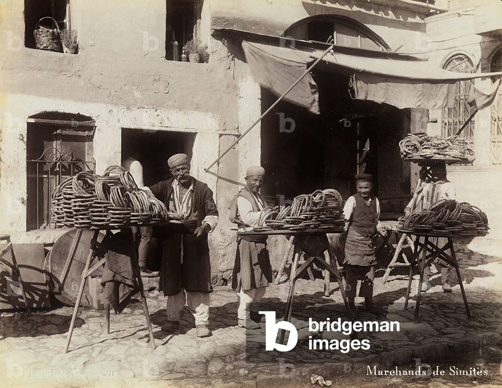A group of Turkish vendors, photographed with their merchandise on display in front of a store, 1890 (print on double-weight paper)