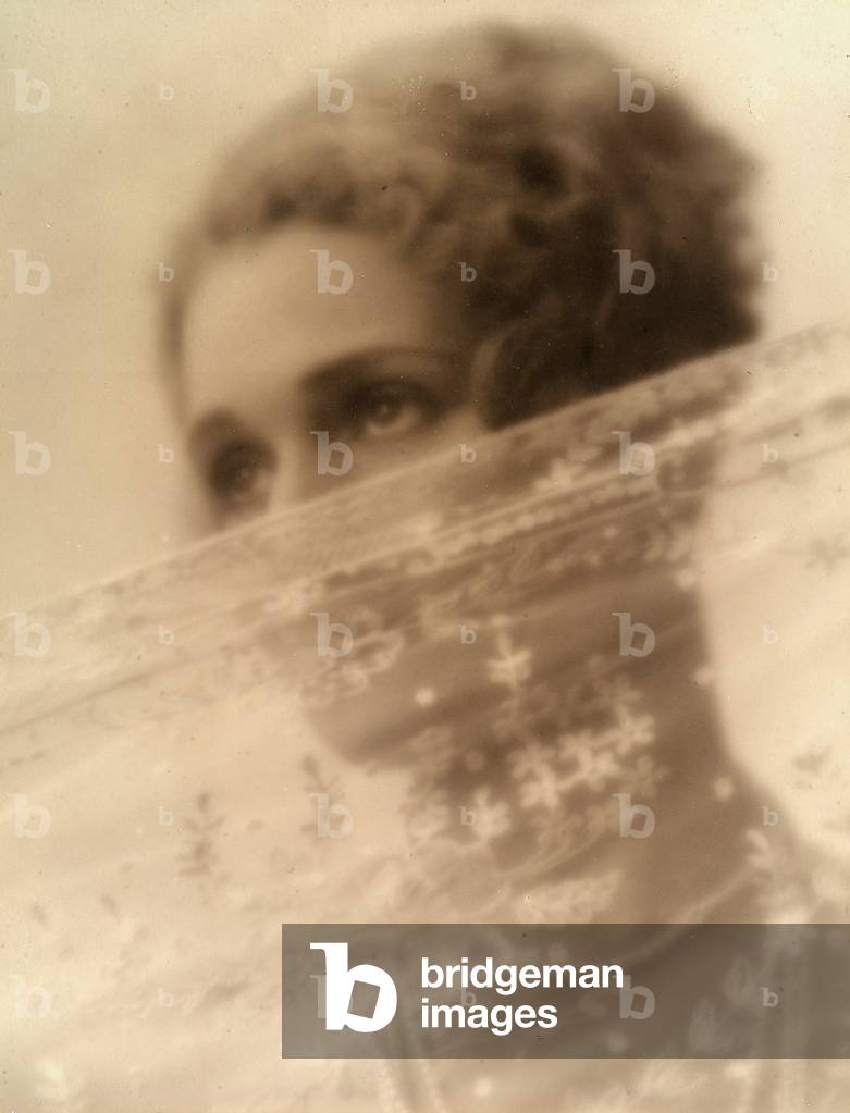 Portrait of a young woman with her face partly covered by a veil