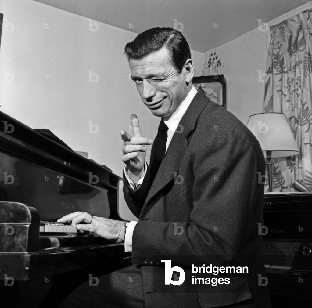 Yves Montand et son piano chez lui à Paris 1957, b/w