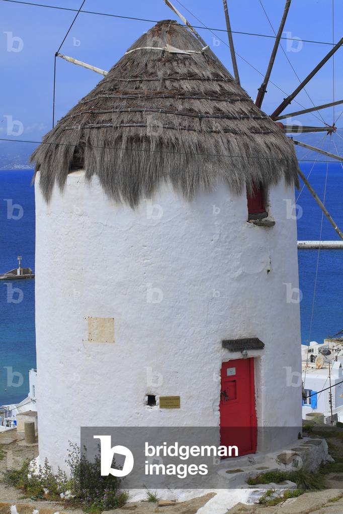 Old traditional Windmill and Cityscape. The main village of Mykonos town (Chora) . Cyclades, Mykonos, Greek islands, Aegean sea.