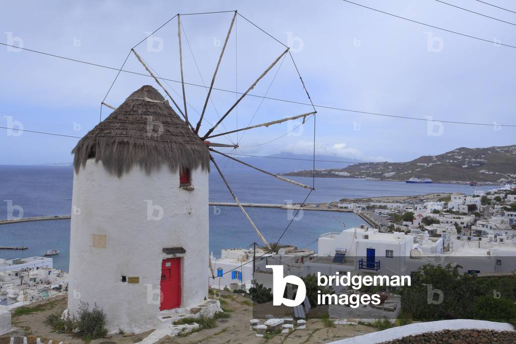Old traditional Windmill and Cityscape. The main village of Mykonos town (Chora) . Cyclades, Mykonos, Greek islands, Aegean sea.