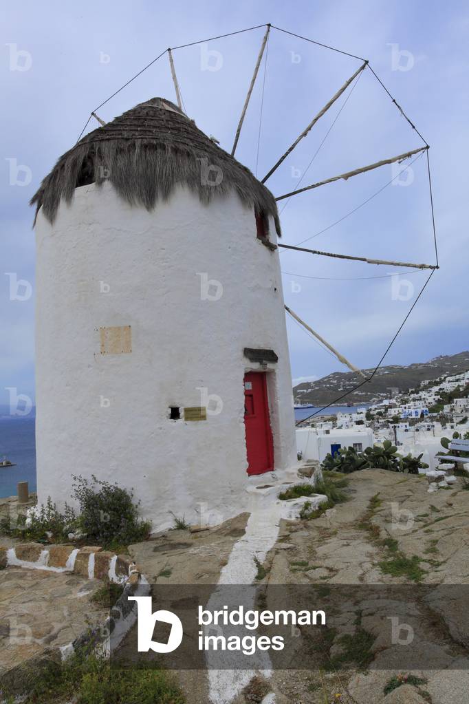 Old traditional Windmill and Cityscape. The main village of Mykonos town (Chora) . Cyclades, Mykonos, Greek islands, Aegean sea.
