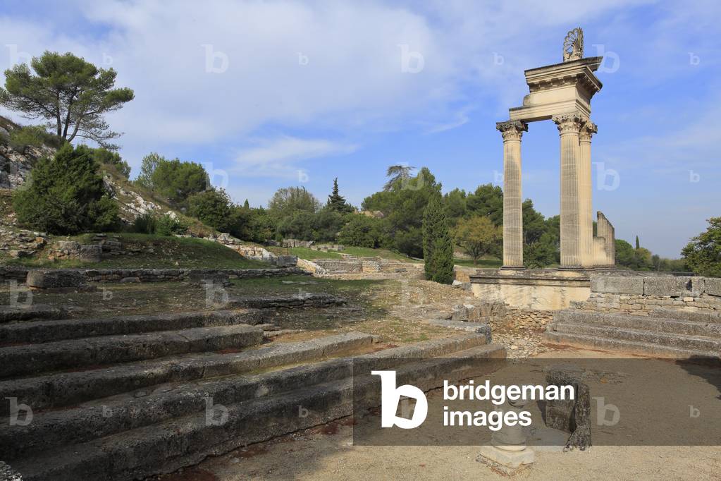 Les temples géminés et bouleuterion: deux temples édifiés en l'honneur de la famille impériale. Le plus petit des deux fut patiellement  restauré au pied duquel se trouve le bouleutérion, assemblée des dignitaires de la période Hellénistique. Site archéologique de Glanum. Région de provence, St- Rémy de Provence, France.

The twin Temples, built in honour of the Emperor's family. The smaller of the two has been partially restored with the bouleuterion, the assembly hall for the dignitaries during the Hellenistic period.  Archeological site of Glanum.  Provence, France. 1st Century BC - 2nd Century AD.
