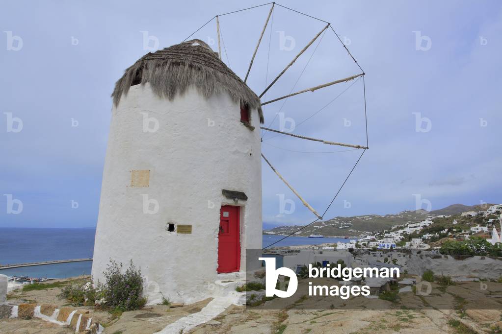 Old traditional Windmill and Cityscape. The main village of Mykonos town (Chora) . Cyclades, Mykonos, Greek islands, Aegean sea.