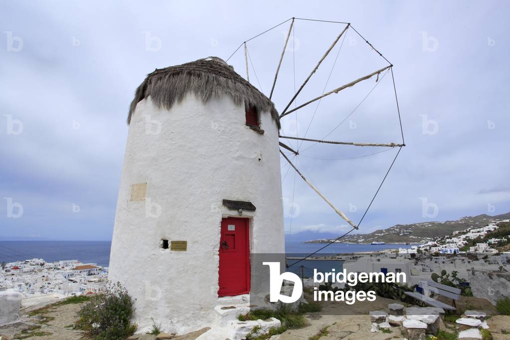 Old traditional Windmill and Cityscape. The main village of Mykonos town (Chora) . Cyclades, Mykonos, Greek islands, Aegean sea.